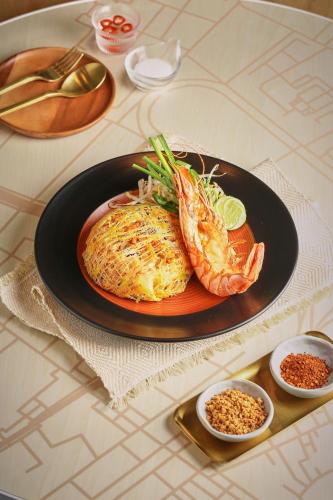 a plate of food with shrimp and other foods on a table at INNSiDE by Meliá Bangkok Sukhumvit in Bangkok