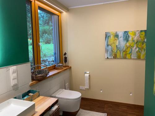 a bathroom with a toilet and a painting on the wall at KatharinaS in Pirmasens