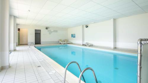 une piscine avec de l'eau bleue dans un immeuble dans l'établissement Les Huskies-51-Appart Renove-6 pers, à Saint-Sorlin-dʼArves