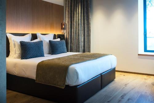 a bedroom with a large bed with blue pillows at Le Pélican in Annecy
