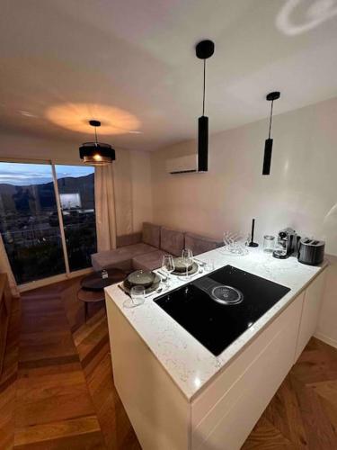une cuisine avec un comptoir et un salon dans l'établissement Appartement rénové entre terre et mer avec piscine, à Calenzana