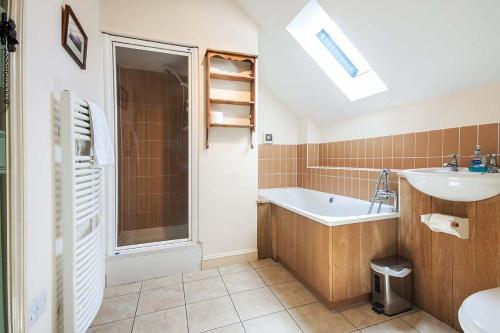 a bathroom with a sink and a bath tub at Mill Village 59, Millstream Cottage - P in Somerford Keynes