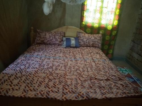 1 dormitorio con 1 cama con edredón en Munyana homestay, en Akagera