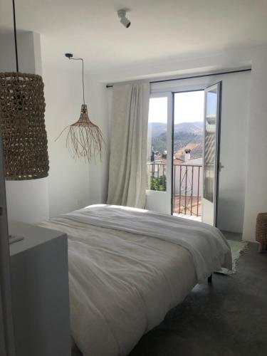 1 dormitorio con cama grande y ventana grande en Casa Trece en Iznájar