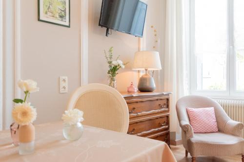 a dining room with a table and two chairs and a television at La Fée Maison in Châtel-sur-Moselle