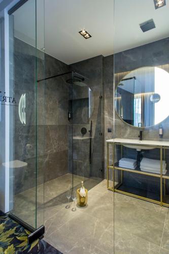 a bathroom with a glass shower with a mirror at Hotel Atrium in Kraków