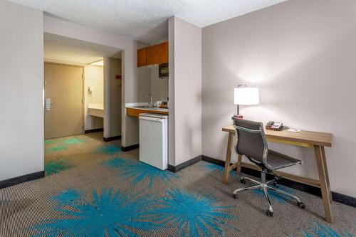 an office with a desk and a chair in a room at Days Inn & Suites by Wyndham Denver International Airport in Denver