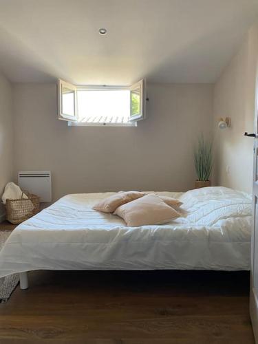 une chambre avec un grand lit blanc avec une fenêtre dans l'établissement La terrasse des Papes, à Avignon