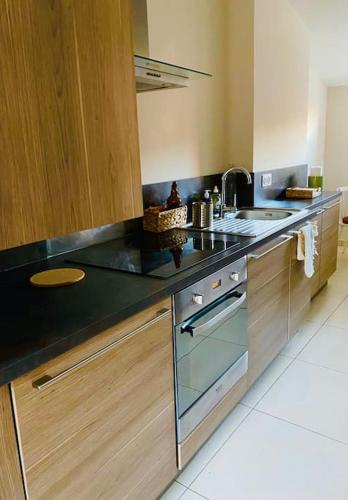 - une cuisine avec un plan de travail noir et un évier dans l'établissement La terrasse des Papes, à Avignon