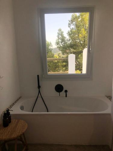 uma banheira num quarto com uma janela em Casa Trece em Iznájar