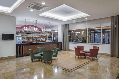 a restaurant with a table and chairs and a bar at Ramada Resort By Wyndham Lara in Lara