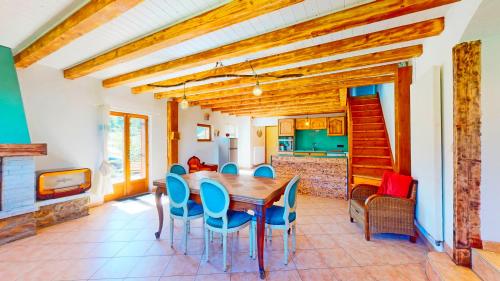 une salle à manger avec une table en bois et des chaises bleues dans l'établissement Calme et chaleureux gîte de campagne., à Voiteur