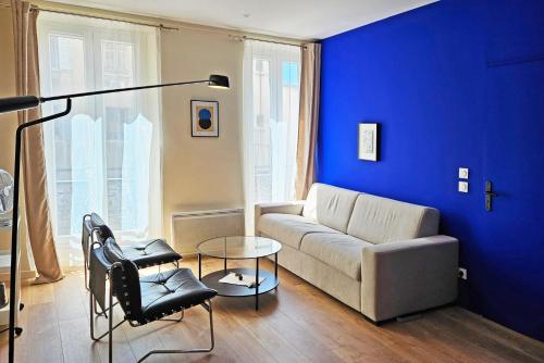 un salon avec un canapé et un mur bleu dans l'établissement La Grande Bleue - Appartement confortable à deux pas du Panier, à Marseille