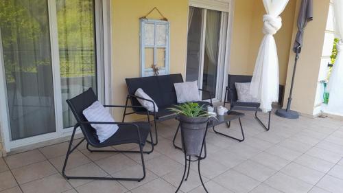 a group of chairs and a table on a porch at Little Paradise in Siviri in Siviri