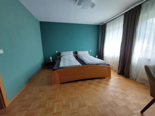 a bedroom with a bed with a blue wall at Ruhe genießen und wohlfühlen auf 70m² in Ober-Laudenbach