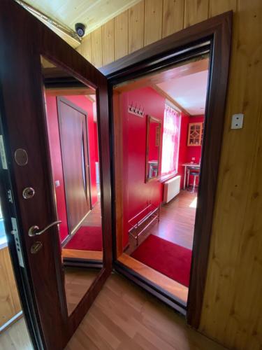 una habitación con paredes rojas y una puerta y un pasillo en Apartamenti, en Riga