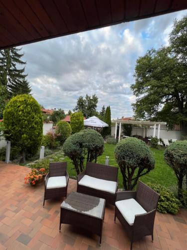 a patio with three chairs and a table and sidx sidx sidx at Zasheva Kushta Guesthouse in Bansko