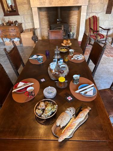 une table en bois avec des assiettes de nourriture dans l'établissement Commanderie Templière de Cazouls d'Hérault, à Cazouls-d Herault