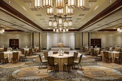 a banquet hall with tables and chairs and chandeliers at DoubleTree by Hilton Ontario Airport in Ontario