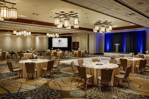a conference room with tables and chairs and a screen at DoubleTree by Hilton Ontario Airport in Ontario