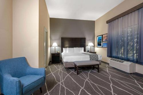 a hotel room with a bed and a chair at La Quinta by Wyndham Houston Energy Corridor in Houston
