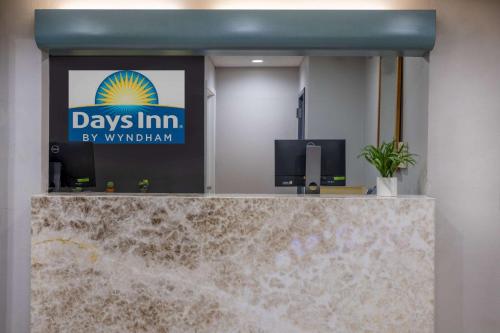 a sign for days inn by waldham in a lobby at Days Inn by Wyndham Pleasant Prairie Kenosha in Kenosha