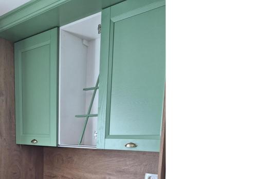 a green cabinet with a mirror in a bathroom at Guesthouse Mare Bar in Bar