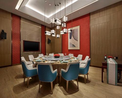 a dining room with a table and blue chairs at Hyatt Regency Shanghai Songjiang in Songjiang