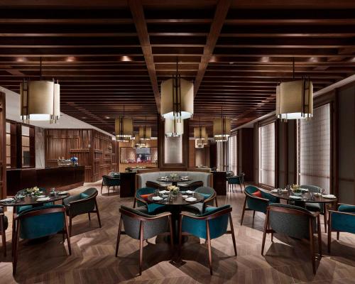 a dining room with tables and chairs and chandeliers at Hyatt Regency Shanghai Songjiang in Songjiang