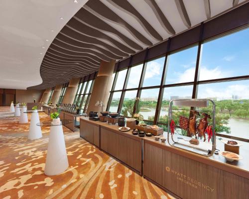 a large lobby with windows and a large aquarium at Hyatt Regency Shanghai Songjiang in Songjiang