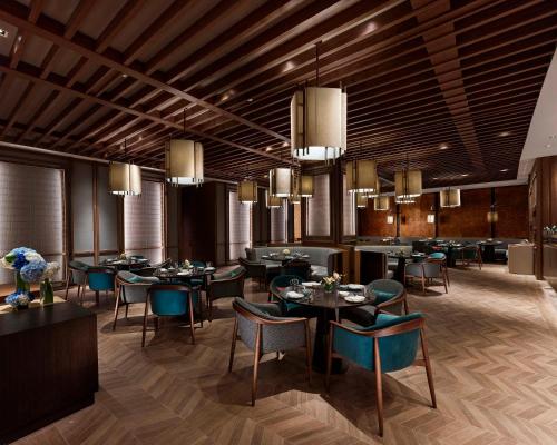 a dining room with tables and chairs and chandeliers at Hyatt Regency Shanghai Songjiang in Songjiang