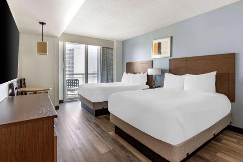 ein Hotelzimmer mit 2 Betten und einem Schreibtisch in der Unterkunft Hilton Vacation Club Oceanaire Virginia Beach in Virginia Beach