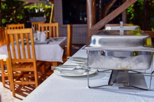 uma grelha sentada em cima de uma mesa com pratos de comida em Mzunguu Safari Lodge em Usa River