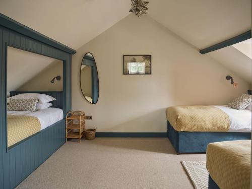 a attic bedroom with two beds and a mirror at Bridge House at Woodhall Estate in Hertford