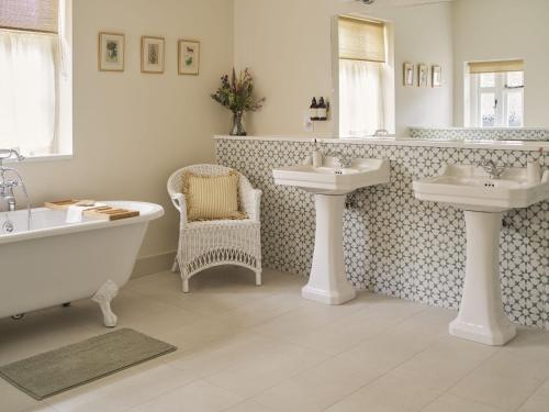 a bathroom with two sinks and a bath tub and a bath tub at Bridge House at Woodhall Estate in Hertford