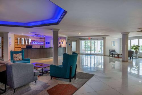 a lobby with chairs and a bar in a hospital at TRYP by Wyndham Tallahassee North I-10 Capital Circle in Tallahassee