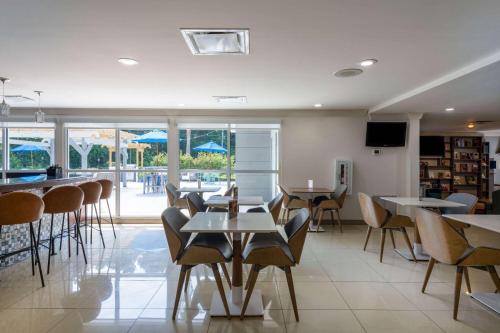 a restaurant with tables and chairs and a bar at TRYP by Wyndham Tallahassee North I-10 Capital Circle in Tallahassee