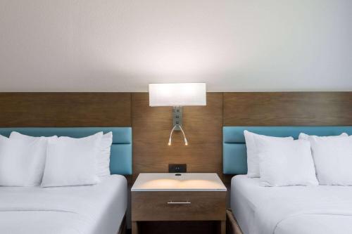 a hotel room with two beds and a lamp at TRYP by Wyndham Tallahassee North I-10 Capital Circle in Tallahassee