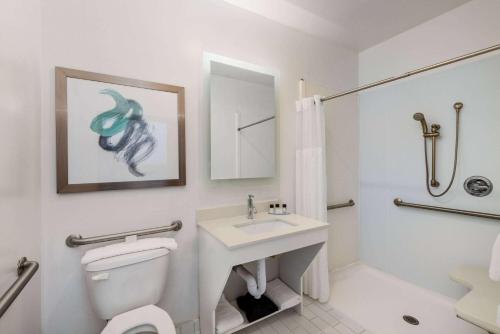 a white bathroom with a toilet and a sink at TRYP by Wyndham Tallahassee North I-10 Capital Circle in Tallahassee