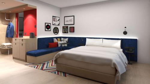 a bedroom with a large bed and a blue couch at Hampton By Hilton Szczecin East in Szczecin