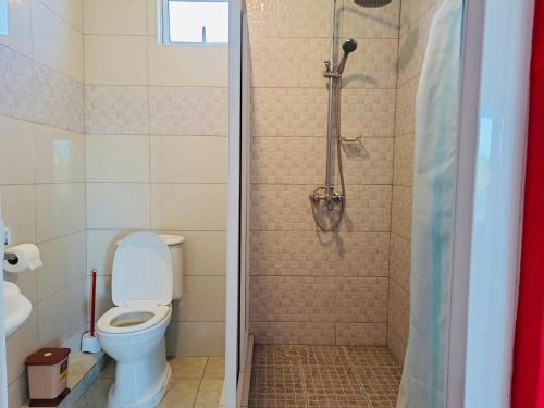 uma casa de banho com um WC e um chuveiro em Spacious Private Rooms with Communal Kitchen em Grand Gaube