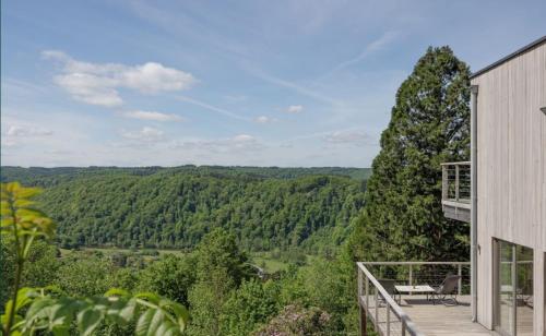 a house with a balcony with a view of the forest at Terra Zen in Rochehaut