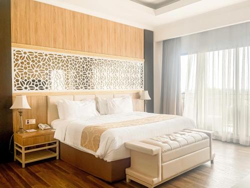 a bedroom with a large bed and a large window at The Green Peak, ARTOTEL Curated in Cisarua