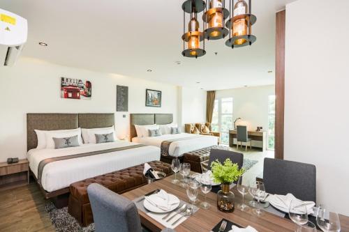 a hotel room with two beds and a dining room at T Pattaya Hotel in Pattaya Central