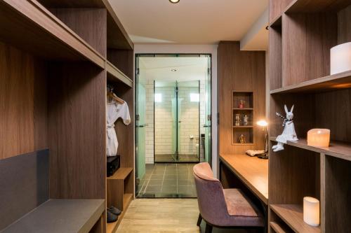 a bathroom with a walk in shower and a walk in closet at T Pattaya Hotel in Pattaya Central