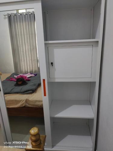 ein weißes Bücherregal in einem Zimmer mit einem Bett in der Unterkunft Sukayadnya house 3 in Sukasada