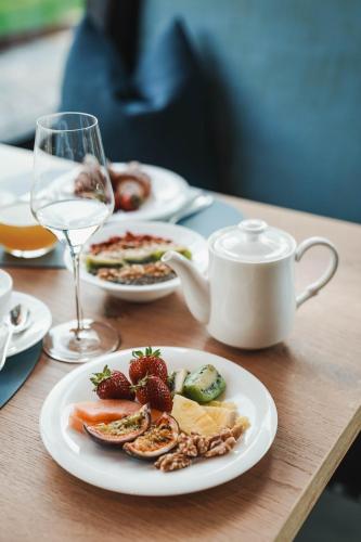 a table with plates of food and a glass of wine at Hotel Dorner B&B in Lagundo