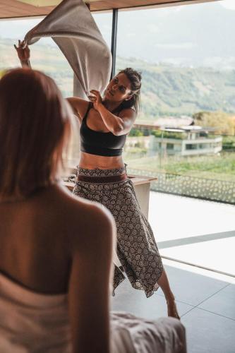 a woman standing in front of a window holding an umbrella at Hotel Dorner B&B in Lagundo