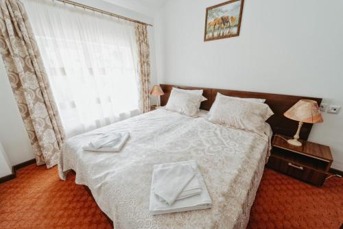 a bedroom with a bed with two white dishes on it at Complex Turistic Constantin Bucovina in Câmpulung Moldovenesc