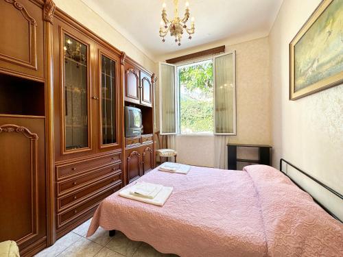 ein Schlafzimmer mit einem Bett, einer Kommode und einem Fenster in der Unterkunft CASA DI LUCA - Le Sorelle - A 1 Minuto Dal Centro in Sanremo